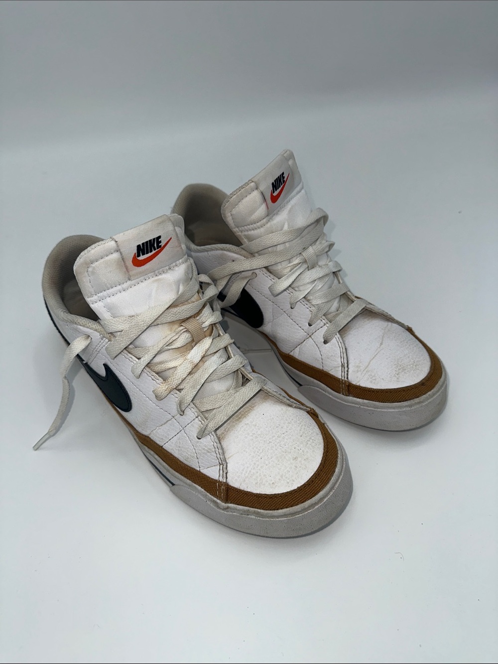 Nike White High-Top Sneakers with Brown Trim and Black Swoosh